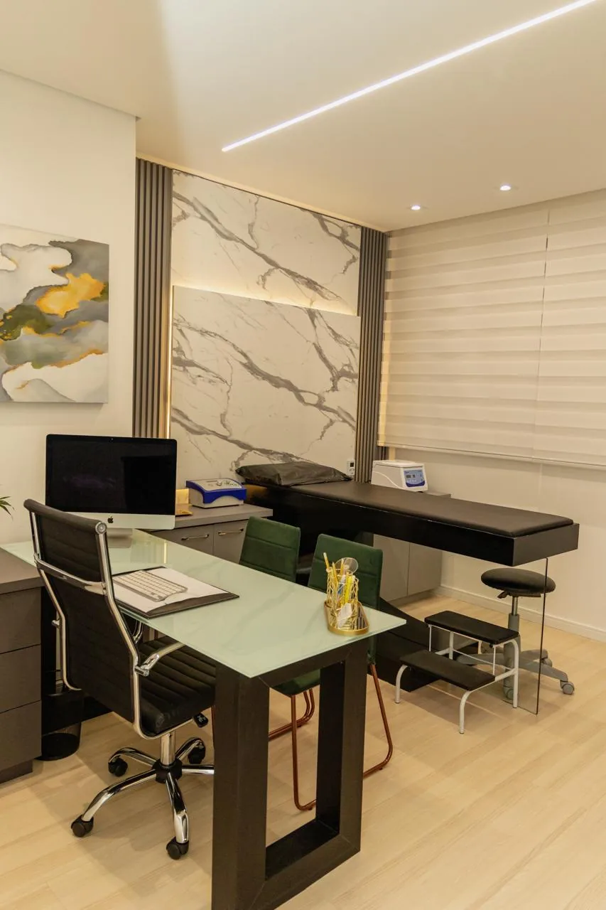 Sala de atendimento do REGENERE com maca, mesa de trabalho e revestimento em mármore
